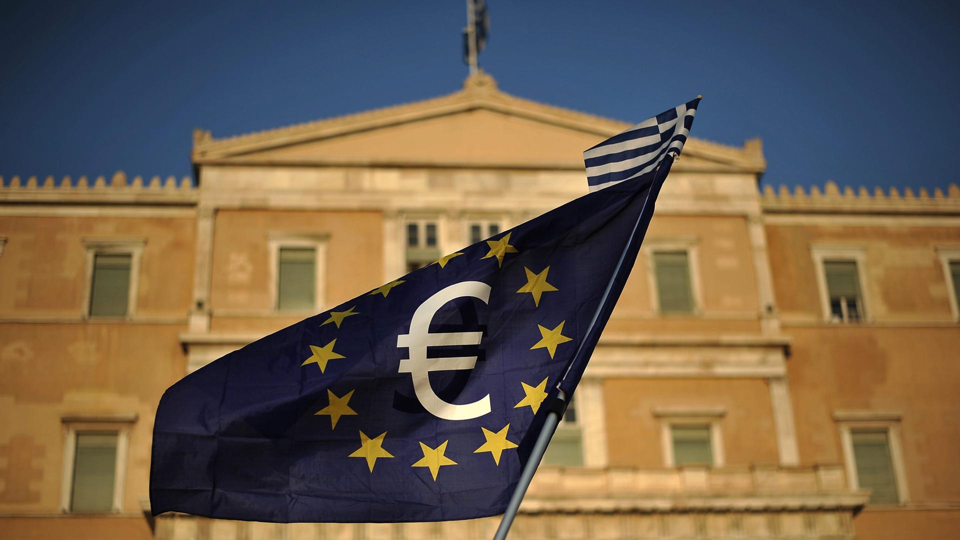 EU-Flagge mit Eurosymbol und einer kleinen griechischen Flagge vor dem Parlament in Athen EU-Flagge mit Eurosymbol und einer kleinen griechischen Flagge vor dem Parlament in Athen