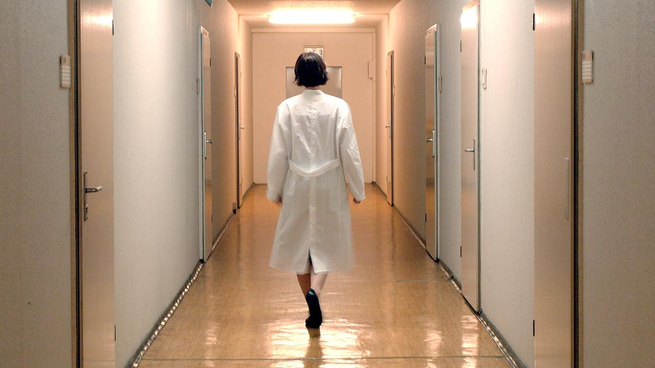 Eine Ärztin läuf allein einen Flur einer Krankenstation in einem Berliner Krankenhaus entlang. Eine Ärztin läuf allein einen Flur einer Krankenstation in einem Berliner Krankenhaus entlang.