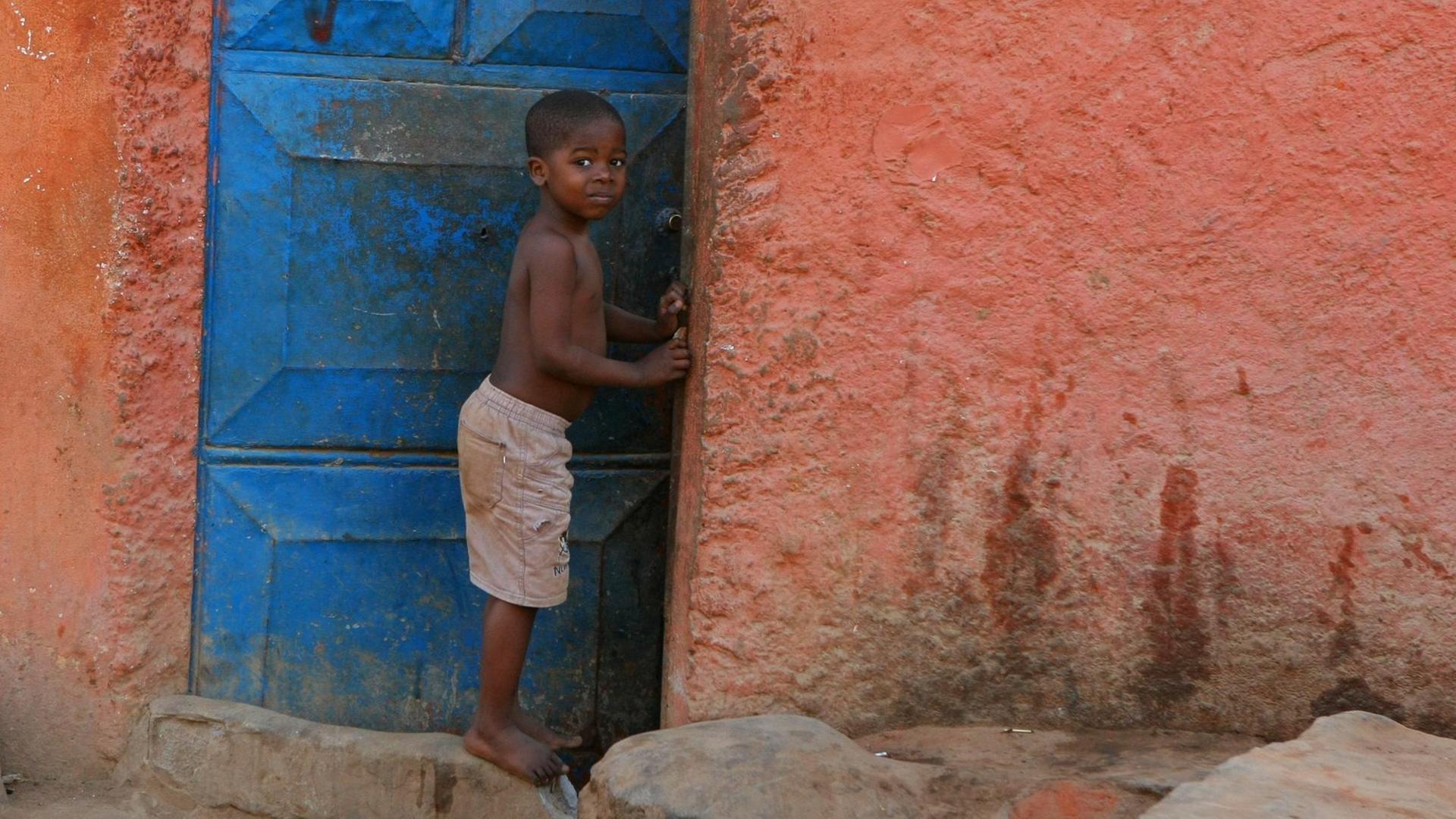 Ein Kind steht vor dem Haus der Familie in Luanda, Angola. Ein Kind steht vor dem Haus der Familie in Luanda, Angola.
