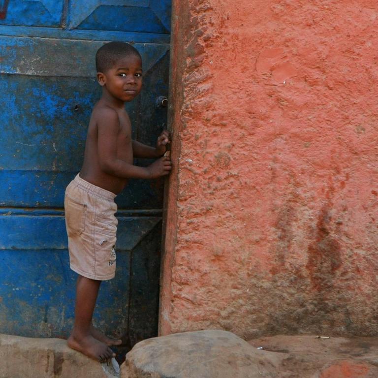Ein Kind steht vor dem Haus der Familie in Luanda, Angola.