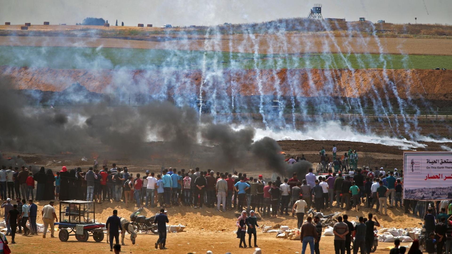 Demonstranten zünden Reifen an, Soldaten schießen mit Tränengas