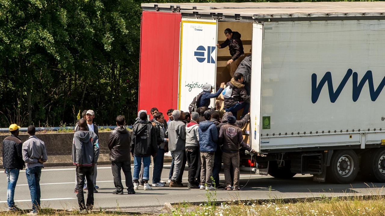 Flüchtlinge kentern einen Lkw, der von Frankreich über den Eurotunnel nach Großbritannien will.
