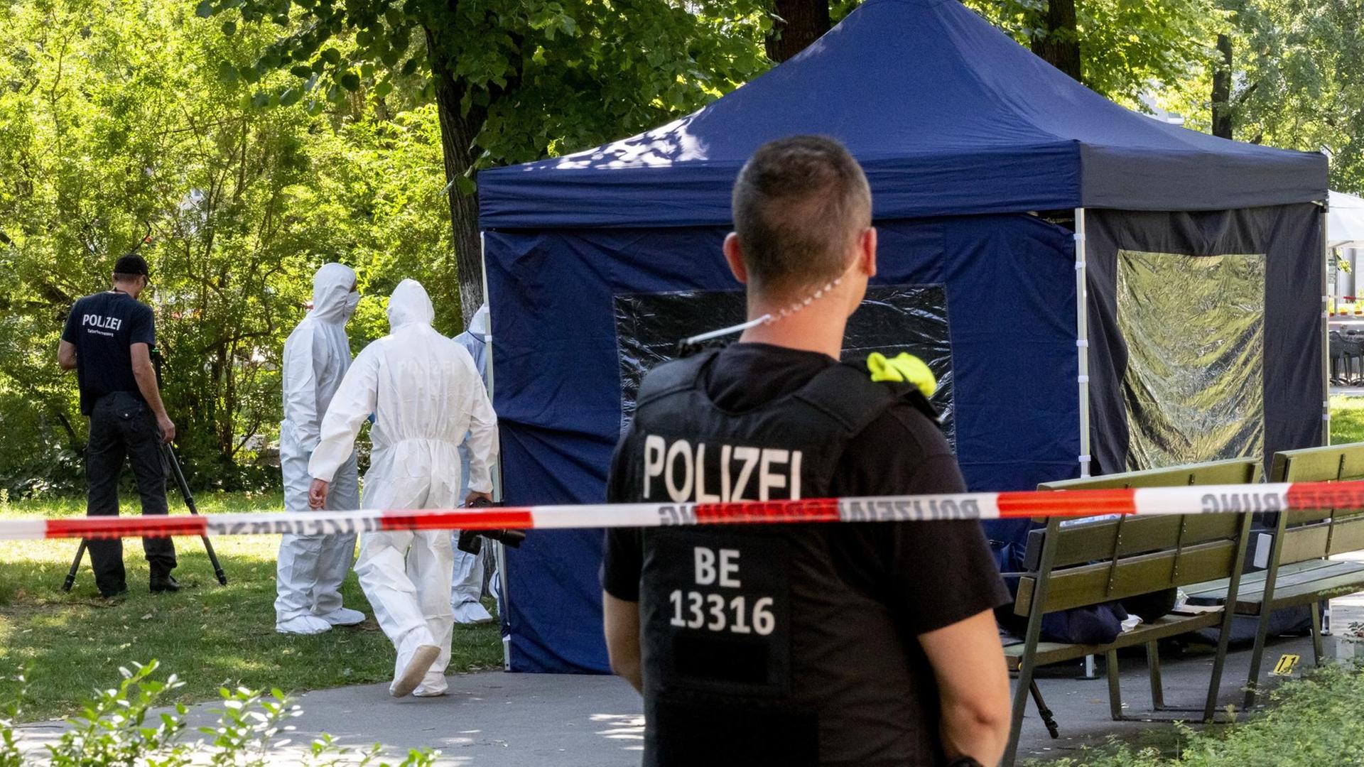 Beamte der Spurensicherung sichern in einem Faltpavillon Spuren am Tatort in Berlin-Moabit. Beamte der Spurensicherung sichern in einem Faltpavillon Spuren am Tatort in Berlin-Moabit.