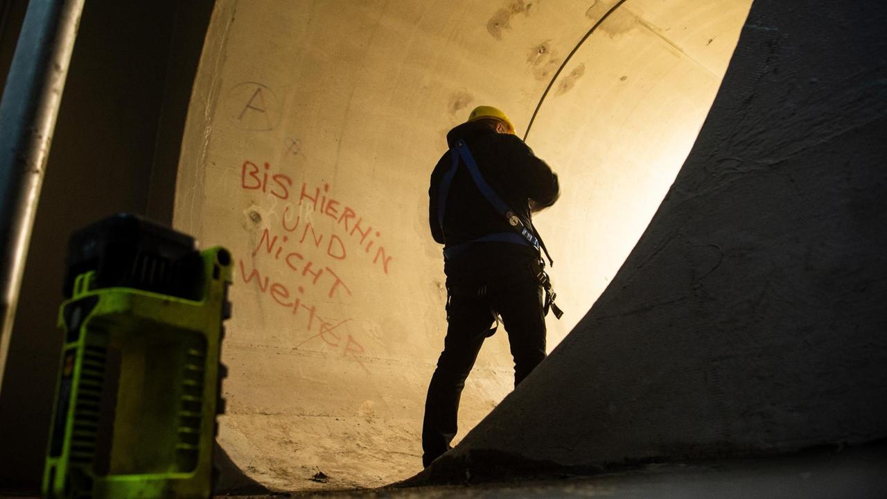 Ein Mann steht im neuen Stauraumkanal am Mauerpark. An der Wand steht „Bis hier hin und nicht weiter“. Die Betonröhre ist deutlich größer im Durchmesser als der Mann. Ein Mann steht im neuen Stauraumkanal am Mauerpark. An der Wand steht „Bis hier hin und nicht weiter“. Die Betonröhre ist deutlich größer im Durchmesser als der Mann.