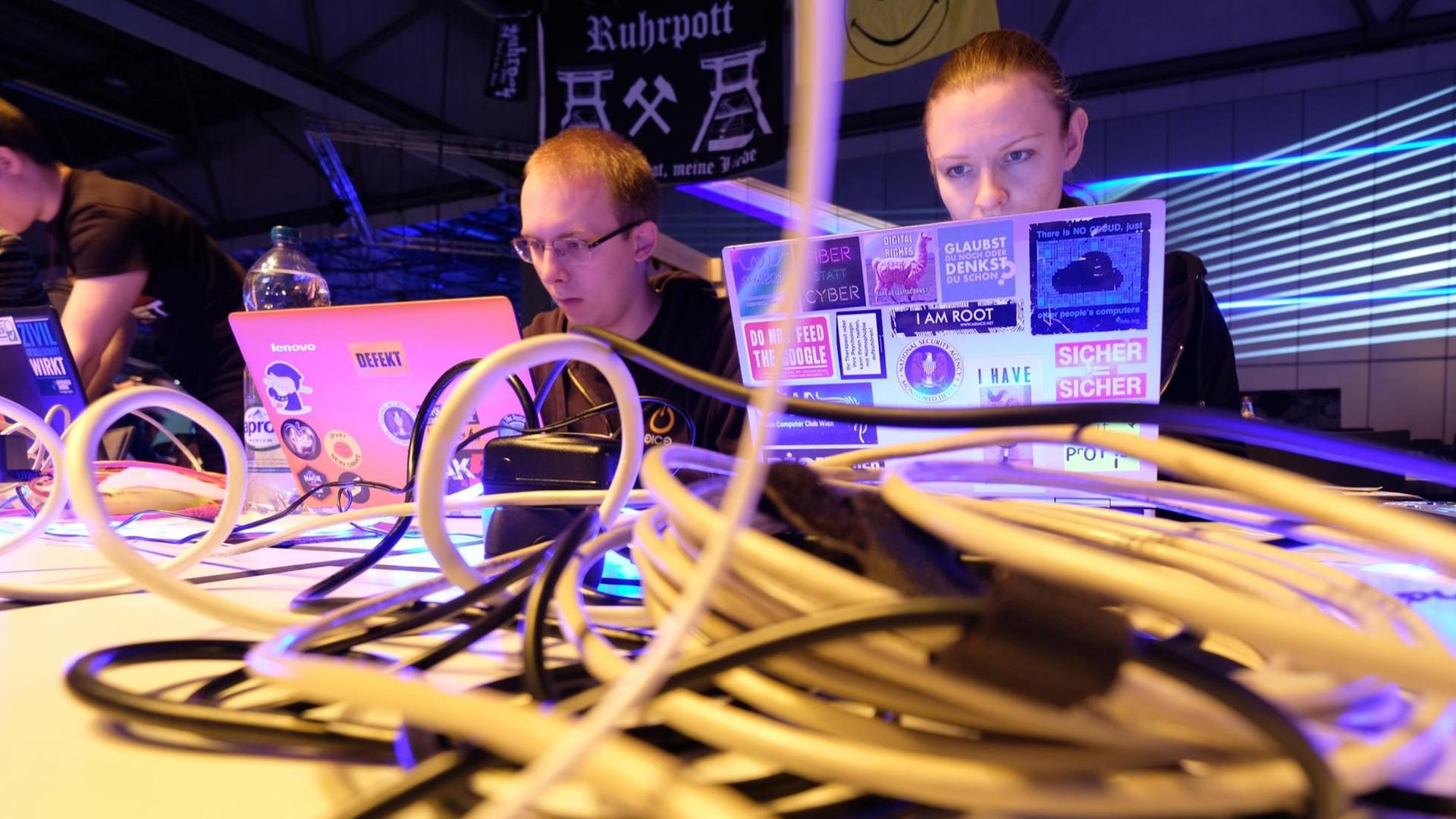 Teilnehmer des 34. Chaos Communication Congress (34c3) arbeiten auf der Messe in Leipzig an ihren Laptops.