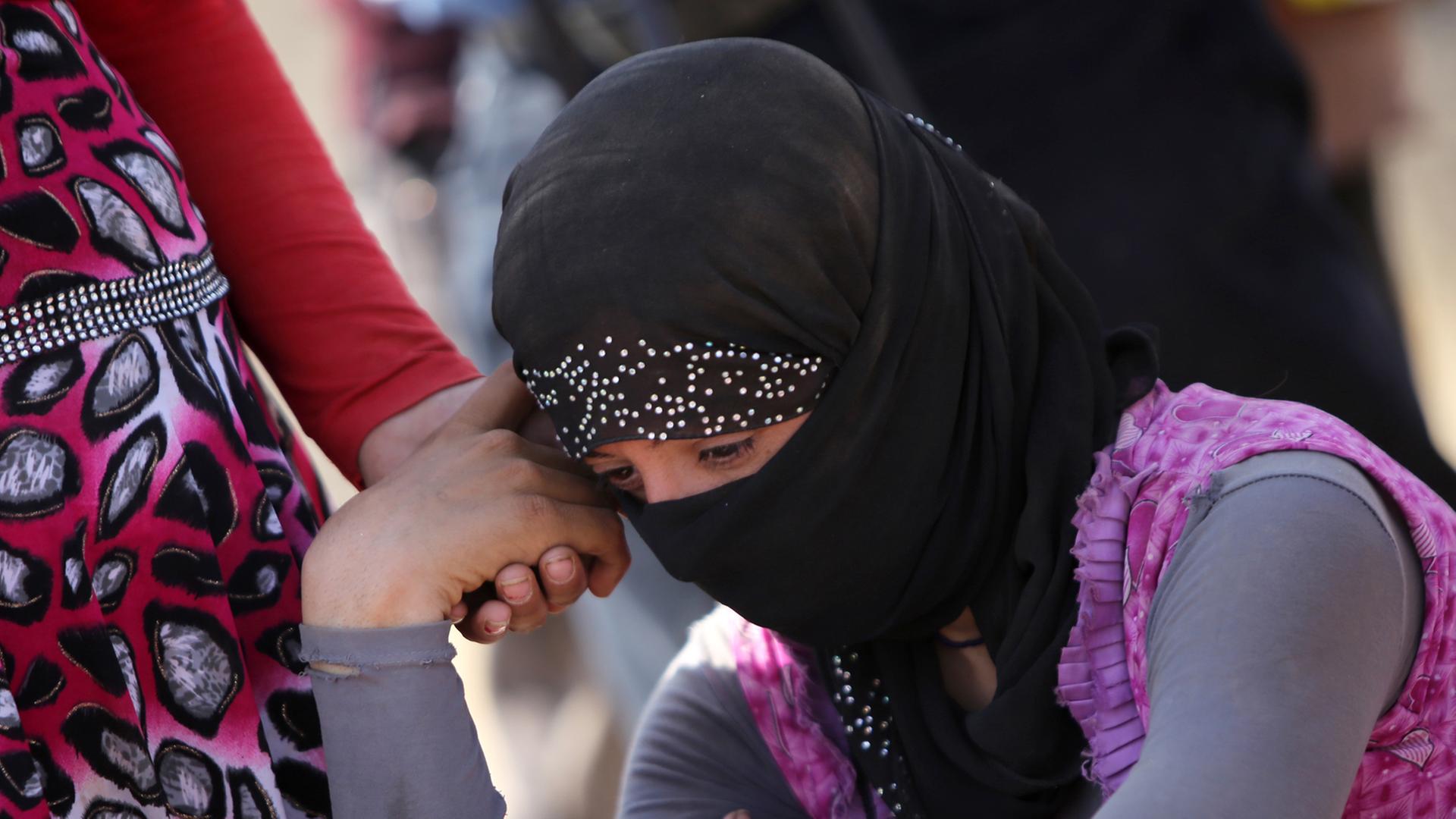Eine jesidische Frau stützt in einem Flüchtlingscamp im Nordirak den Kopf auf die Hand Eine jesidische Frau stützt in einem Flüchtlingscamp im Nordirak den Kopf auf die Hand