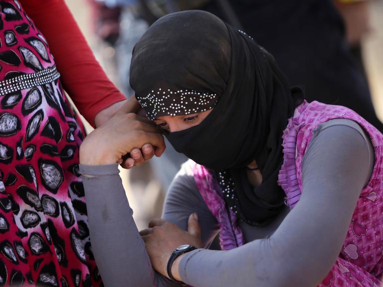Eine jesidische Frau stützt in einem Flüchtlingscamp im Nordirak den Kopf auf die Hand