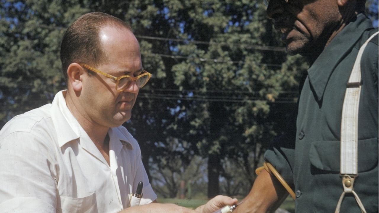 Ein Foto aus den 1950er-Jahren zeigt einen weißen Arzt, der einem schwarzen Farmer in Tuskegee Blut abnimmt. Im Rahmen einer Syphilis-Epidemie wurden die schwarzen Farmer entgegen aller ethischen Konventionen nur mit Placebos behandelt, um die Langzeitfolgen der Krankheit zu studieren.  