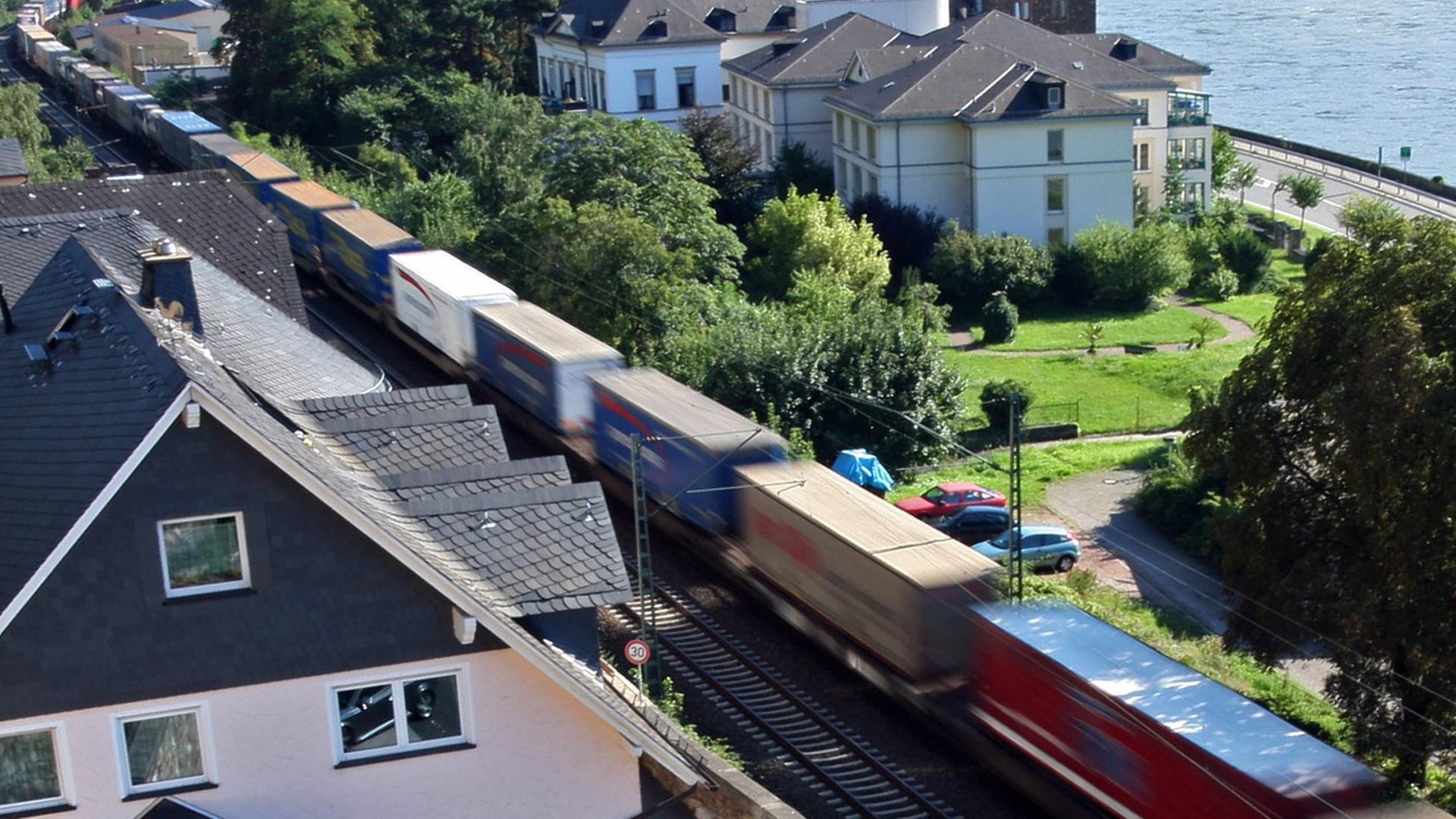 Ein Güterzug fährt an Häusern in Assmanshausen (Rüdesheim) vorbei Ein Güterzug fährt an Häusern in Assmanshausen (Rüdesheim) vorbei