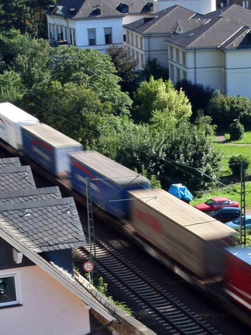 Ein Güterzug fährt an Häusern in Assmanshausen (Rüdesheim) vorbei