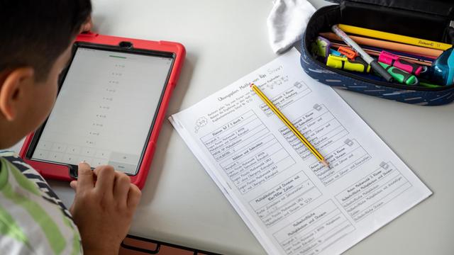 Ein Schüler arbeitet in einer Grundschule an einem Tablet