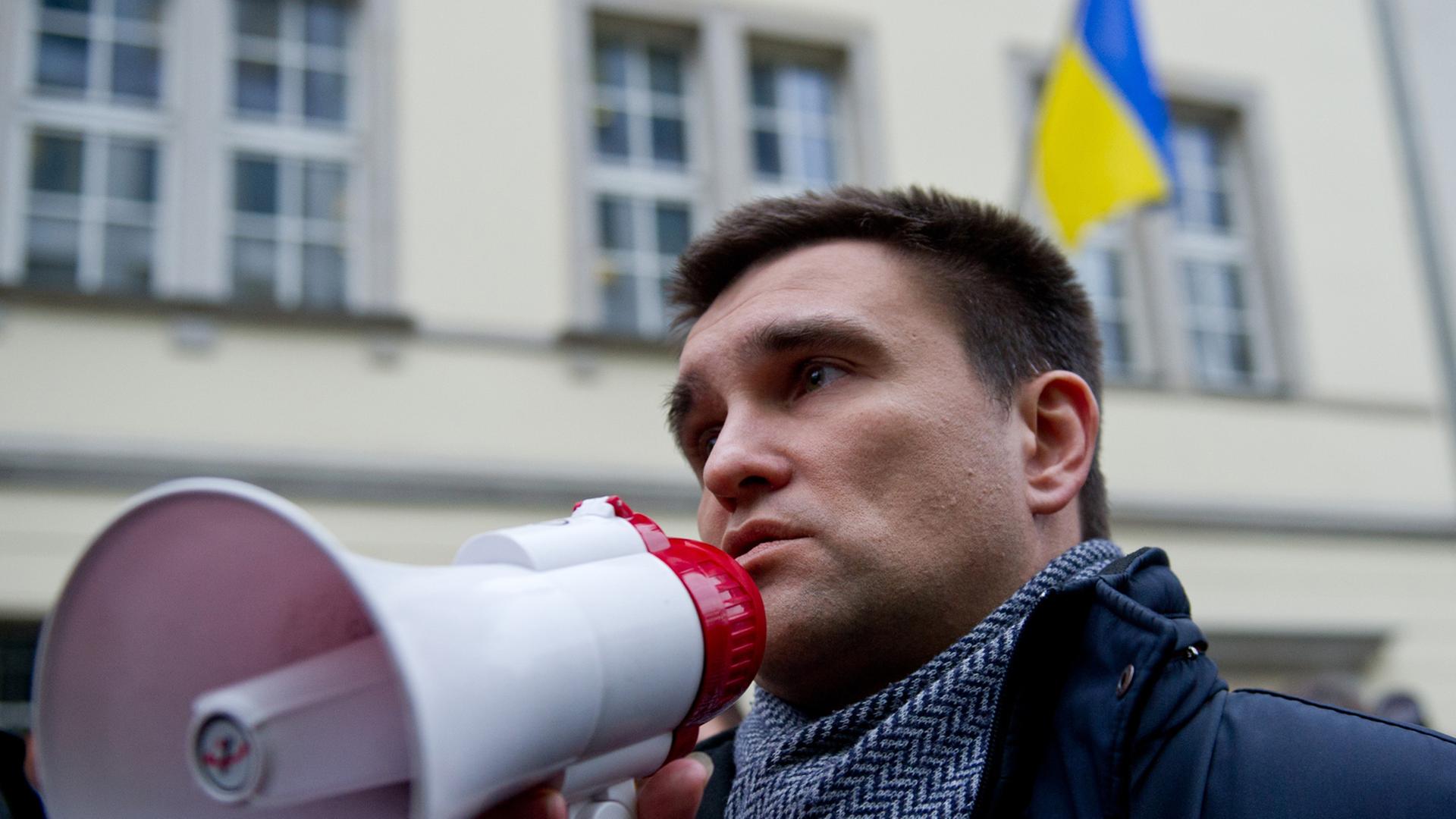 Der ukrainische Botschafter in Deutschland, Pavlo Klimkin, spricht in ein Megaphon, im Hintergrund mehrere Menschen und das Botschaftsgebäude mit der ukrainischen Flagge Der ukrainische Botschafter in Deutschland, Pavlo Klimkin, spricht in ein Megaphon, im Hintergrund mehrere Menschen und das Botschaftsgebäude mit der ukrainischen Flagge