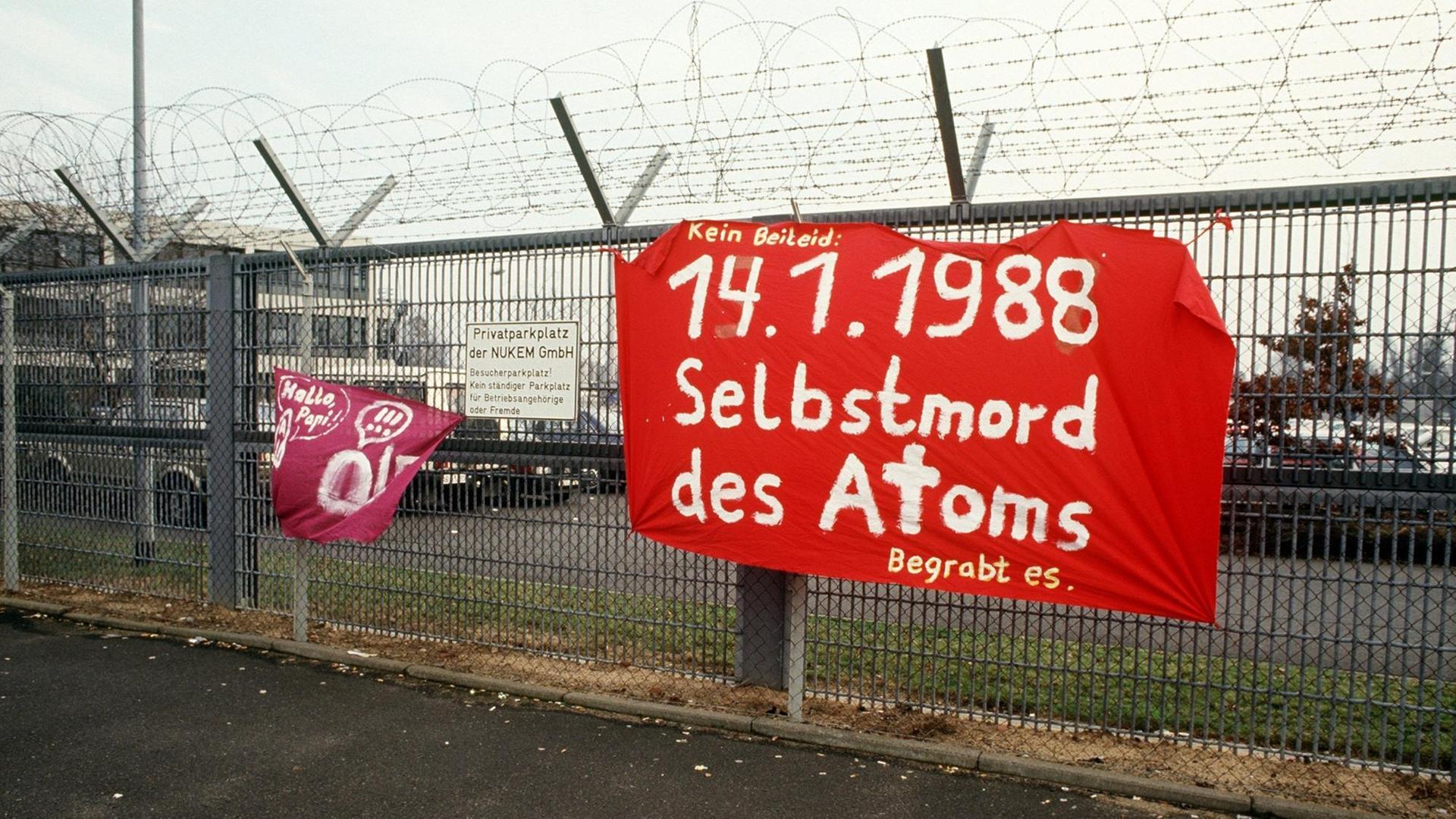 Atomkraft-Gegner haben am 14.1.1988 an dem mit Stacheldraht gesicherten Sperrzaun auf dem Gelände der Hanauer Atomfabrik Nukem ein Plakat angebracht. Die Firma wurde wegen unerlaubter Transport von spaltbarem Material und dem Verdacht illegaler Auslandslieferungen geschlossen. Atomkraft-Gegner haben am 14.1.1988 an dem mit Stacheldraht gesicherten Sperrzaun auf dem Gelände der Hanauer Atomfabrik Nukem ein Plakat angebracht. Die Firma wurde wegen unerlaubter Transport von spaltbarem Material und dem Verdacht illegaler Auslandslieferungen geschlossen.