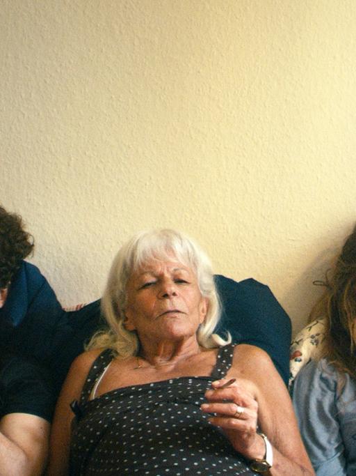 Drei Figuren aus dem Film "Frau Stern" sitzen gemeinsam auf dem Sofa und rauchen Marihuana.