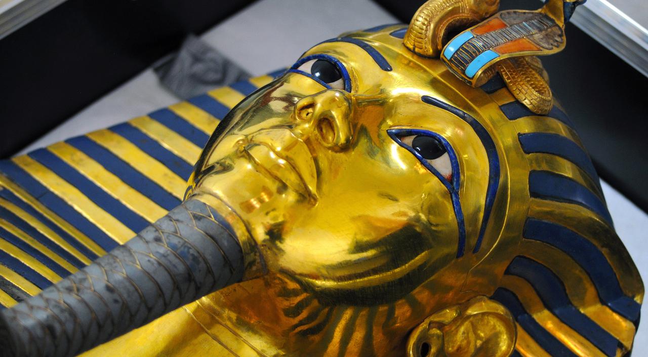 Die Totenmaske von Tutanchamun im Ägyptischen Museum in Kairo. Die Totenmaske des Tutanchamun im Ägyptischen Museum, aufgenommen am 12.10.2015. Durch eine Unachtsamkeit brach im August 2014 der Zeremonialbart der goldenen Totenmaske des Pharaos Tutanchamun im Ägyptischen Museum in Kairo ab. Daraufhin wurde der Bart mit einem Epoxitkleber eilig wieder an die Maske geklebt. Seit einiger Zeit ist ein Restauratorenteam vom Römisch-Germanischen Zentralmuseum in Mainz damit beschäftigt, die Maske zu restaurieren, soweit dies möglich ist. Mit Lindenholzstäbchen wird Millimeter für Millimeter des Klebers mechanisch abgetragen, Ende des Jahres, so hofft man, sei diese Arbeit erledigt. Die Totenmaske von Tutanchamun im Ägyptischen Museum in Kairo. Die Totenmaske des Tutanchamun im Ägyptischen Museum, aufgenommen am 12.10.2015. Durch eine Unachtsamkeit brach im August 2014 der Zeremonialbart der goldenen Totenmaske des Pharaos Tutanchamun im Ägyptischen Museum in Kairo ab. Daraufhin wurde der Bart mit einem Epoxitkleber eilig wieder an die Maske geklebt. Seit einiger Zeit ist ein Restauratorenteam vom Römisch-Germanischen Zentralmuseum in Mainz damit beschäftigt, die Maske zu restaurieren, soweit dies möglich ist. Mit Lindenholzstäbchen wird Millimeter für Millimeter des Klebers mechanisch abgetragen, Ende des Jahres, so hofft man, sei diese Arbeit erledigt.