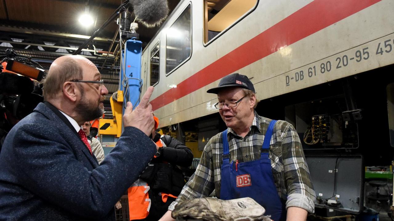 Der designierte SPD-Kanzlerkandidat Martin Schulz (l) steht am 07.02.2017 im Bahn-Werk Neumünster (Schleswig-Holstein) an einem Waggon und spricht mit einem Mitarbeiter.