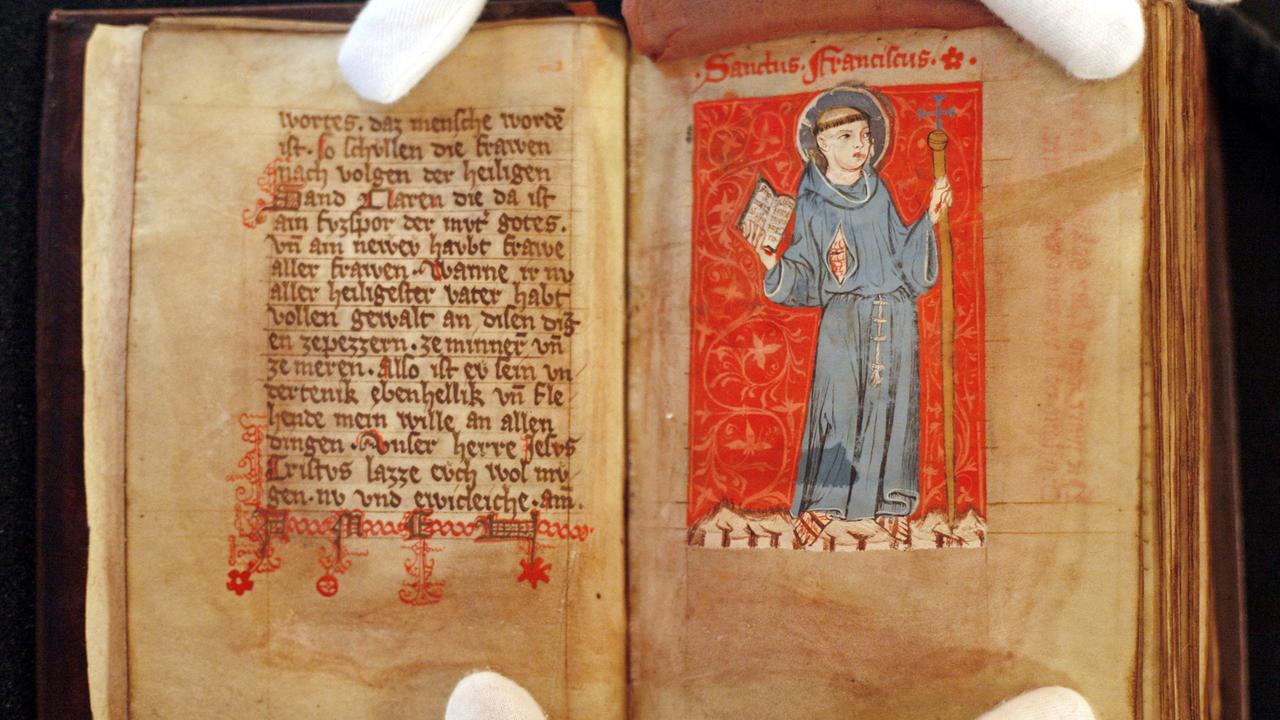 Das Bild des heiligen Franziskus ist im aufgeschlagenen St. Klara-Buch während einer Präsentation mittelalterlicher Handschriften in der Universitätsbibliothek Leipzig zu sehen. Das Bild des heiligen Franziskus ist im aufgeschlagenen St. Klara-Buch während einer Präsentation mittelalterlicher Handschriften in der Universitätsbibliothek Leipzig zu sehen.