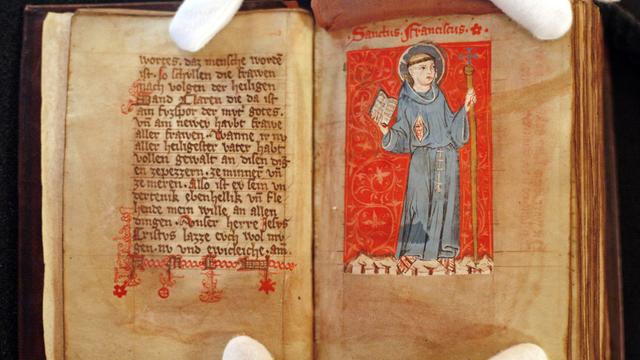 Das Bild des heiligen Franziskus ist im aufgeschlagenen St. Klara-Buch während einer Präsentation mittelalterlicher Handschriften in der Universitätsbibliothek Leipzig zu sehen. 