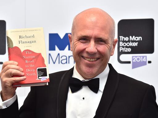 Der australische Autor Richard Flanagan posiert mit seinem Buch "The Narrow Road to the Deep North", für das er mit dem Booker Prize 2014 ausgezeichnet wurde.