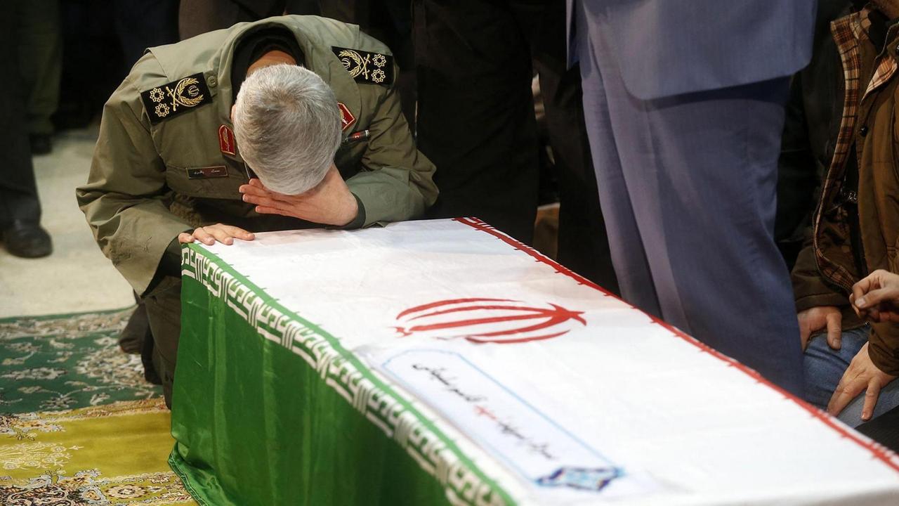 Bei der Beerdigung von General Soleimani beugt sich ein trauernder Mann über dessen Sarg.
Bei der Beerdigung von General Soleimani beugt sich ein trauernder Mann über dessen Sarg.