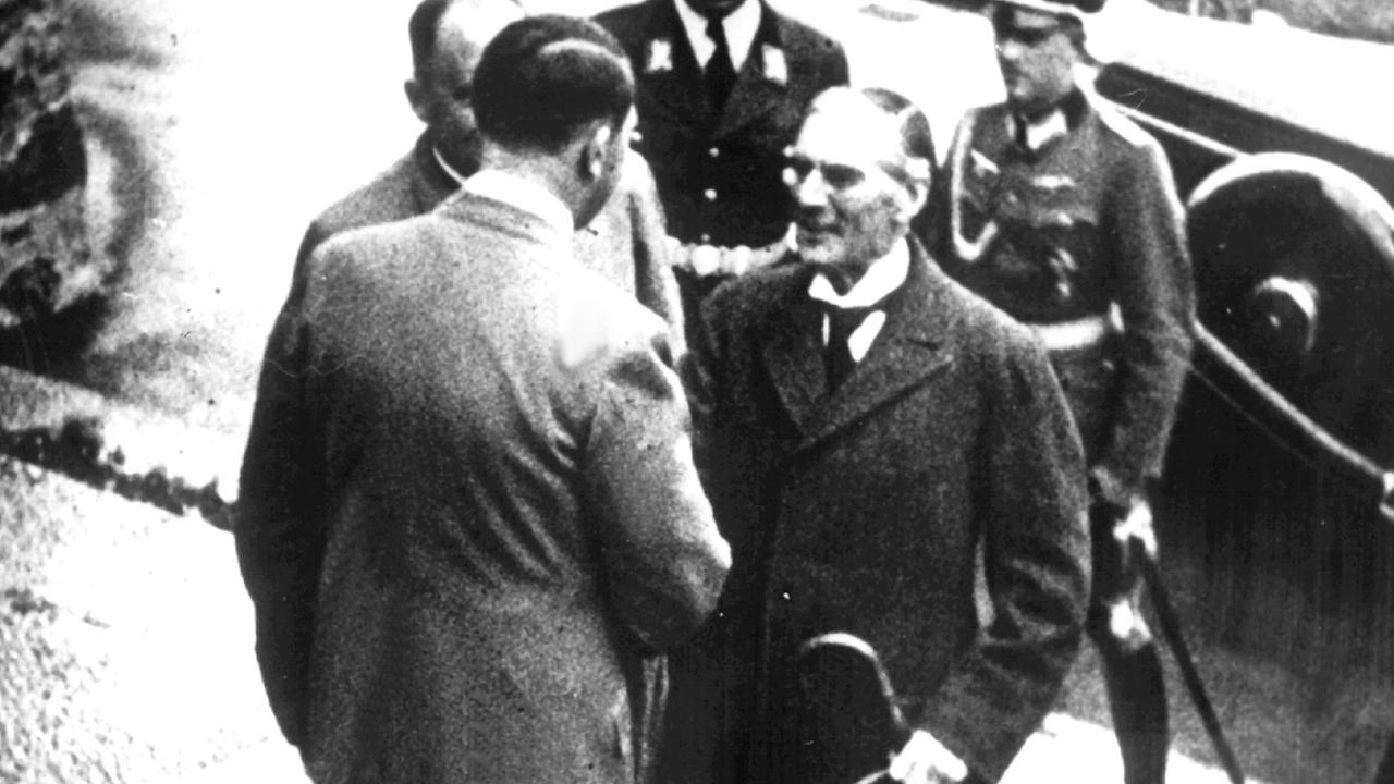 Adolf Hitler, ein paar Stufen über Arthur Neville Chamberlain stehend, schüttelt ihm die Hand Adolf Hitler, ein paar Stufen über Arthur Neville Chamberlain stehend, schüttelt ihm die Hand