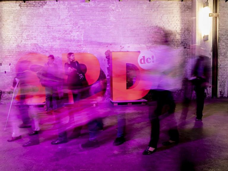 11.11.2018, Berlin: Teilnehmer des SPD-Debattencamp laufen vor einem SPD-Logo (Aufnahme mit Langzeitbelichtung).