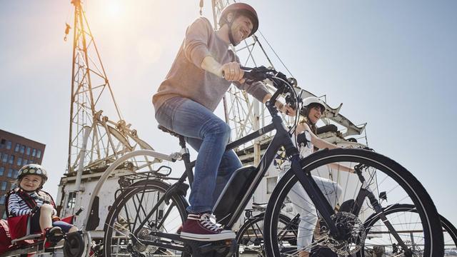 In Hamburg am Hafen fährt eine Familie mit ihren E-Bikes.