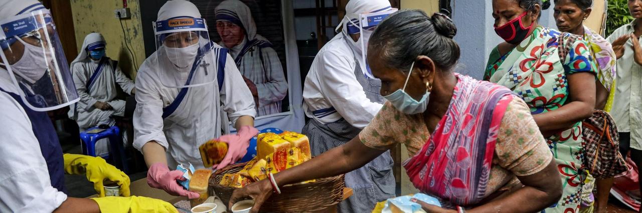 Indien, Kolkata: Nonnen des katholischen Ordens "Missionarinnen der Nächstenliebe", gegründet von Mutter Teresa, tragen Mundschutze und Gesichtsschutze bei der Verteilung von Nahrungsmittel an arme und obdachlose Menschen. Indien, Kolkata: Nonnen des katholischen Ordens "Missionarinnen der Nächstenliebe", gegründet von Mutter Teresa, tragen Mundschutze und Gesichtsschutze bei der Verteilung von Nahrungsmittel an arme und obdachlose Menschen.