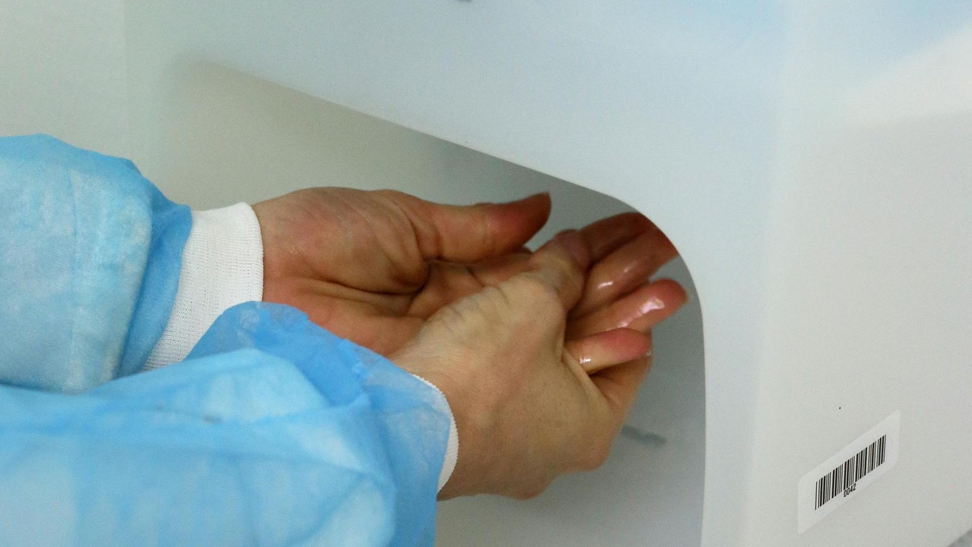 Ein Arzt desinfiziert sich seine Hände im Krankenhaus Ein Arzt desinfiziert sich seine Hände im Krankenhaus