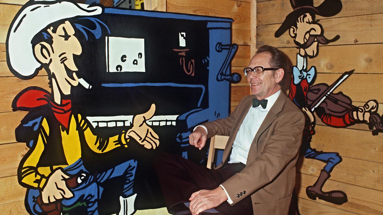 Das Foto zeigt den Zeichner Maurice de Bévère, besser bekannt als Morris, im Jahr 1985 mit seiner Comicfigur Lucky Luke auf einer Ausstellung im château de la Chapelle d'Angillon.