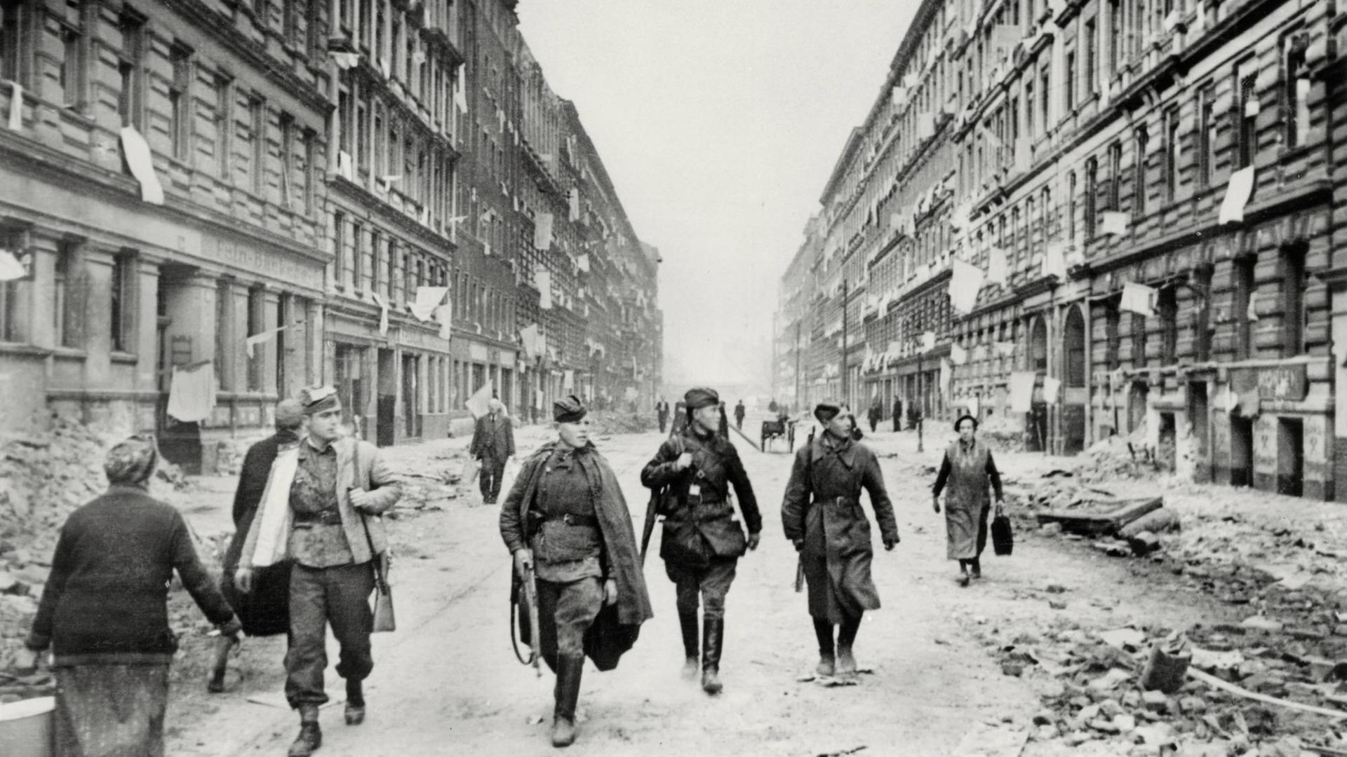 2. Weltkrieg / Eroberung von Berlin durch die Rote Armee, 16. April bis zur Kapitulation am 2. Mai 1945. Sowjetsoldaten ziehen durch eine Straße Berlins. Aus den Fenstern der Häuser hängen als Zeichen der Kapitulation weiße Fahnen. Foto, 1. Mai 1945. | 2. Weltkrieg / Eroberung von Berlin durch die Rote Armee, 16. April bis zur Kapitulation am 2. Mai 1945. Sowjetsoldaten ziehen durch eine Straße Berlins. Aus den Fenstern der Häuser hängen als Zeichen der Kapitulation weiße Fahnen. Foto, 1. Mai 1945. |