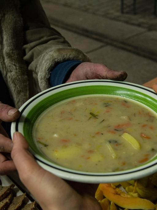 Ein Obdachloser bekommt am 19.02.2014 in Berlin eine Suppe in einer Wärmelufthalle. Die Berliner Stadtmission hat das provisorisch errichtete Gebäude als Nachtquartier für Obdachlose unweit des Innsbrucker Platzes vorgesehen.