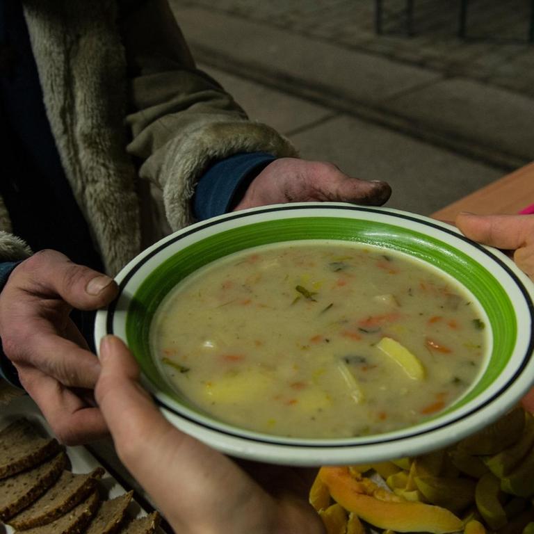 Ein Obdachloser bekommt am 19.02.2014 in Berlin eine Suppe in einer Wärmelufthalle. Die Berliner Stadtmission hat das provisorisch errichtete Gebäude als Nachtquartier für Obdachlose unweit des Innsbrucker Platzes vorgesehen.