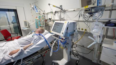 Ein Patient liegt in der Intensivstation an einem Beatmungsgerät.