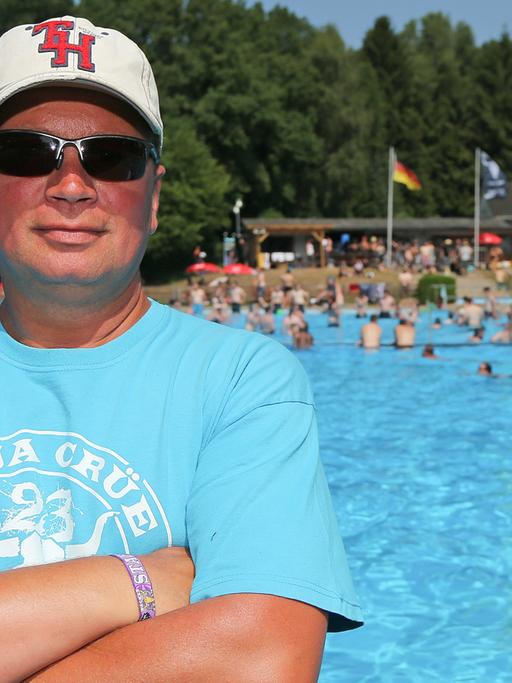 Schwimmmeister Ingo Schwarz steht in Wacken (Schleswig-Holstein) in "seinem" Freibad am Beckenrand.