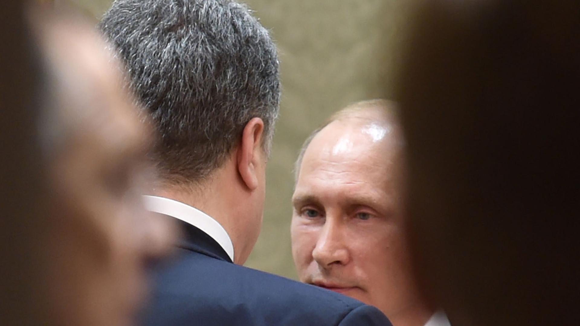 Der russische Präsident Wladimir Putin (hinten) spricht während des Minsker Ukraine-Gipfels mit dem ukrainischen Staatschef Petro Poroschenko. Der russische Präsident Wladimir Putin (hinten) spricht während des Minsker Ukraine-Gipfels mit dem ukrainischen Staatschef Petro Poroschenko.