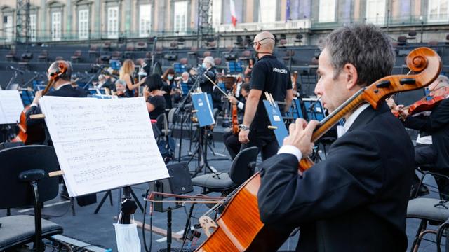 Mitglieder des Orchesters stimmen ihre Instrumente auf dem Piazza de Plebiscito in Neapel vor der Premiere der Oper "Aida", Juli 2020