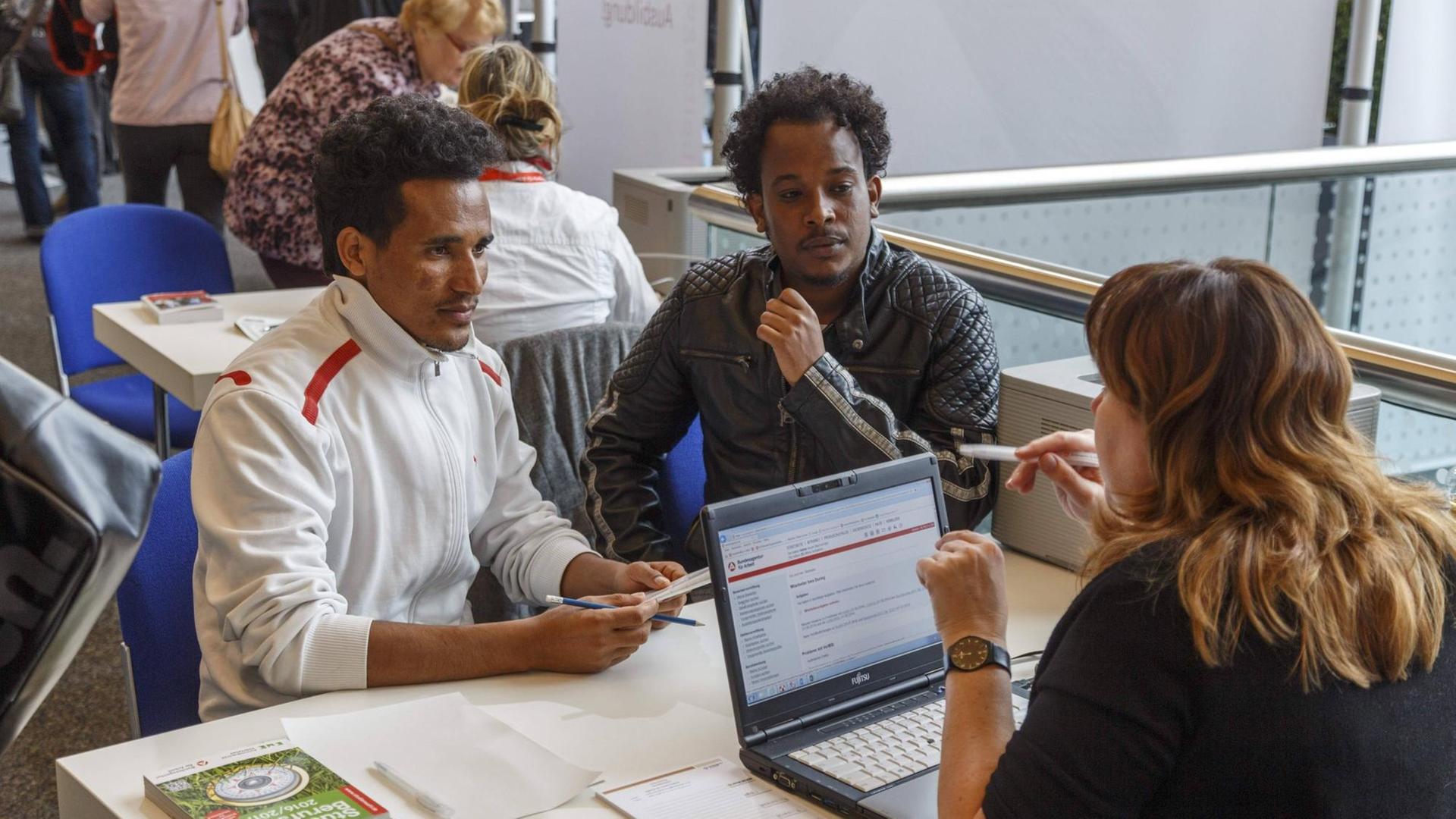 Zwei Männer aus dem Land Eritrea in Afrika sitzen bei einer Job-Börse einer Beraterin gegenüber. Zwei Männer aus dem Land Eritrea in Afrika sitzen bei einer Job-Börse einer Beraterin gegenüber.