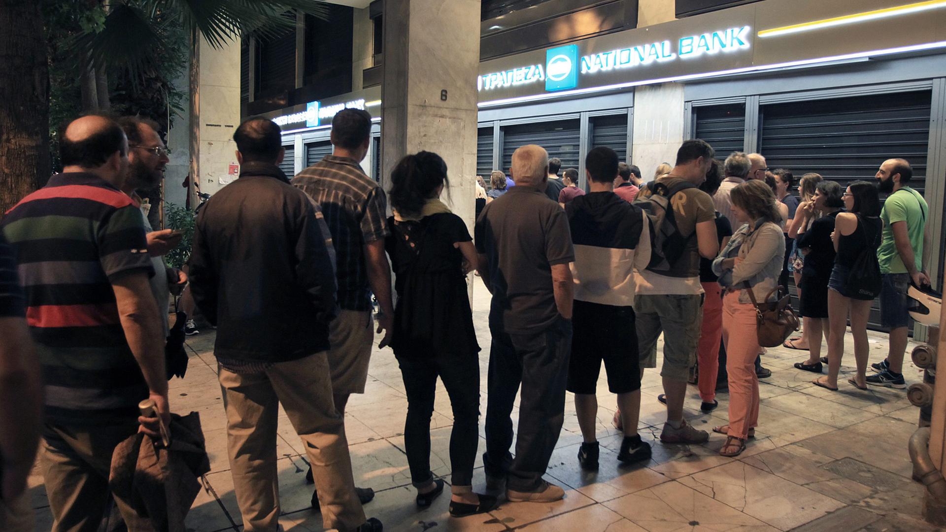 In Athen stehen Menschen vor einem Geldautomat Schlange In Athen stehen Menschen vor einem Geldautomat Schlange