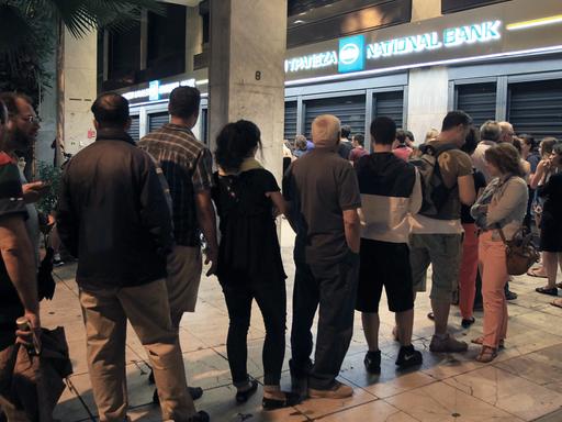 In Athen stehen Menschen vor einem Geldautomat Schlange