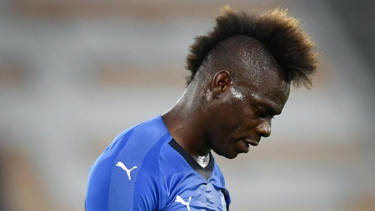 Balotelli in Nahaufnahme mit hängendem Kopf. Er trägt einen auffälligen Irokesen-Haarschnitt. Balotelli in Nahaufnahme mit hängendem Kopf. Er trägt einen auffälligen Irokesen-Haarschnitt.