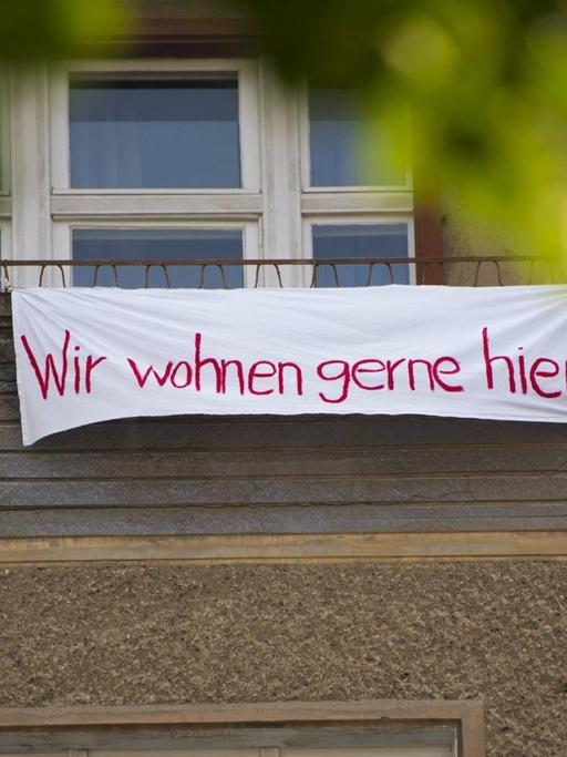 Protestplakat an der Fassade des Wohnhauses Krossener Strasse 36 in Friedrichshain. Darauf steht "Wir wohnen gerne hier." Das Haus wurde an die Aramid GmbH verkauft. Bis zum 10.6.2019 läuft die Frist für die Ausübung des bezirklichen Vorkaufsrechts.