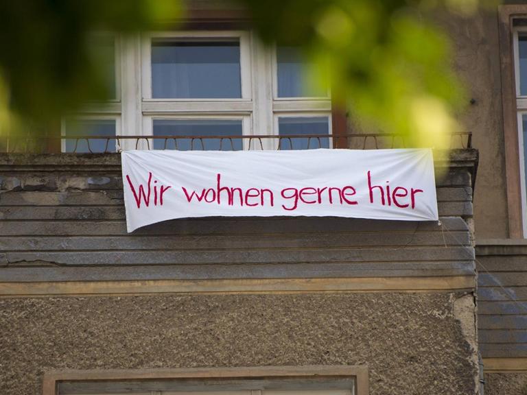 Protestplakat an der Fassade des Wohnhauses Krossener Strasse 36 in Friedrichshain. Darauf steht "Wir wohnen gerne hier." Das Haus wurde an die Aramid GmbH verkauft. Bis zum 10.6.2019 läuft die Frist für die Ausübung des bezirklichen Vorkaufsrechts.