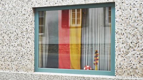 Deutsche Fahne und Ball hinter einem Fenster