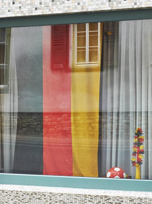 Deutsche Fahne und Ball hinter einem Fenster