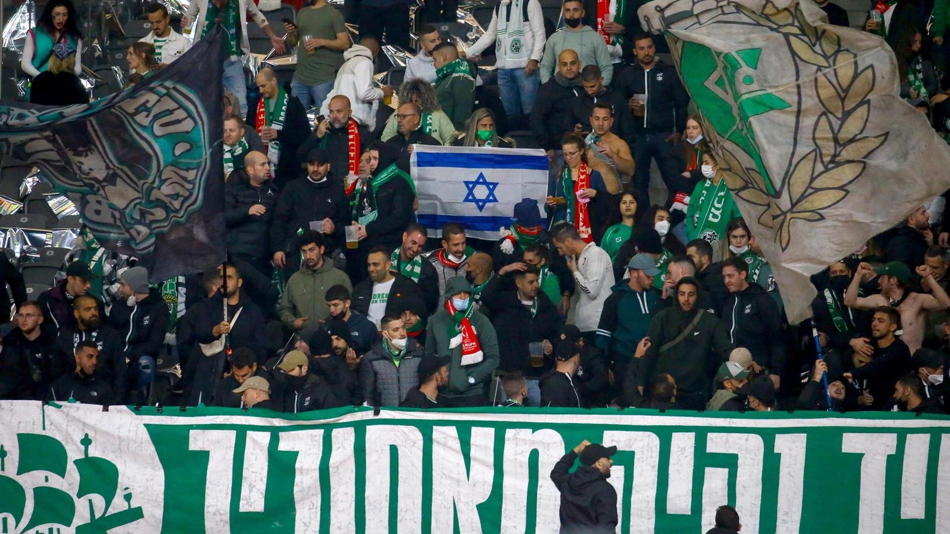 Fans von Maccabi Haifa schwenken die israelische Flagge. Fans von Maccabi Haifa schwenken die israelische Flagge.