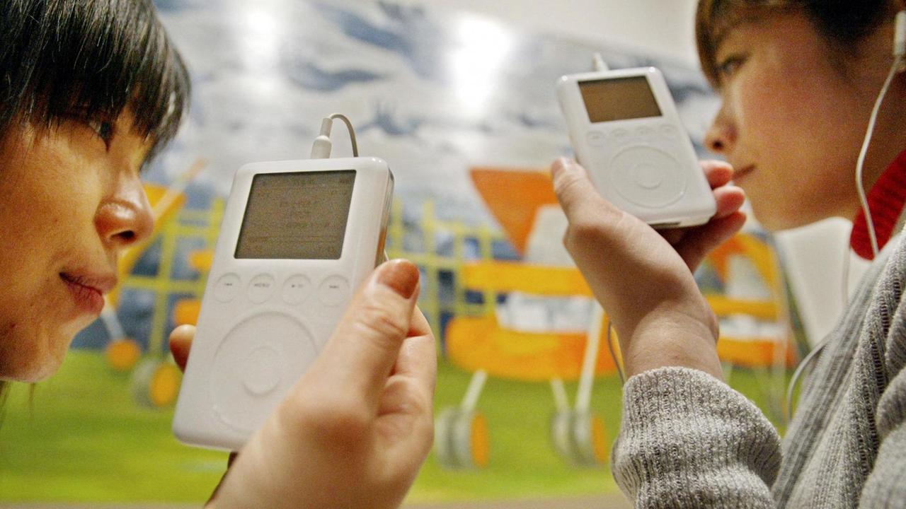 Zwei Japanerinnen hören Musik auf dem Apple iPod der ersten Generation.