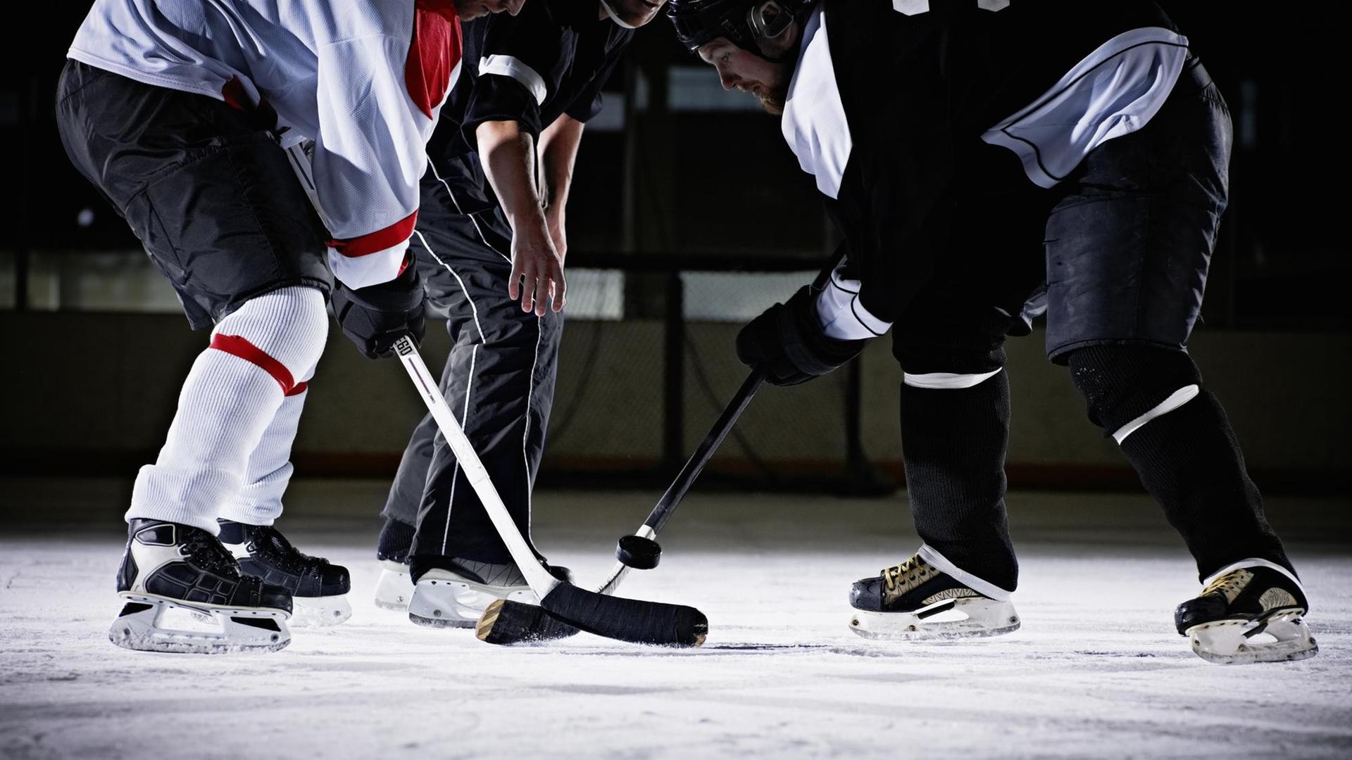 Zwei Eis-Hockey-Spieler kämpfen um den Puck. Zwei Eis-Hockey-Spieler kämpfen um den Puck.