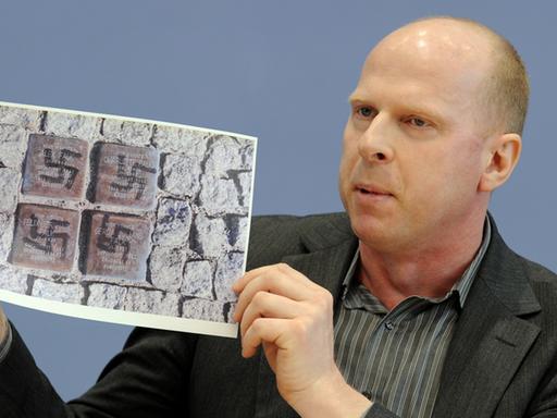 Jörg Wanke von der Bürgerinitiative "Zossen zeigt Gesicht" zeigt rechtsextreme Schmierereien aus seiner Gemeinde in Brandenburg (Archivbild vom 8. März 2010).