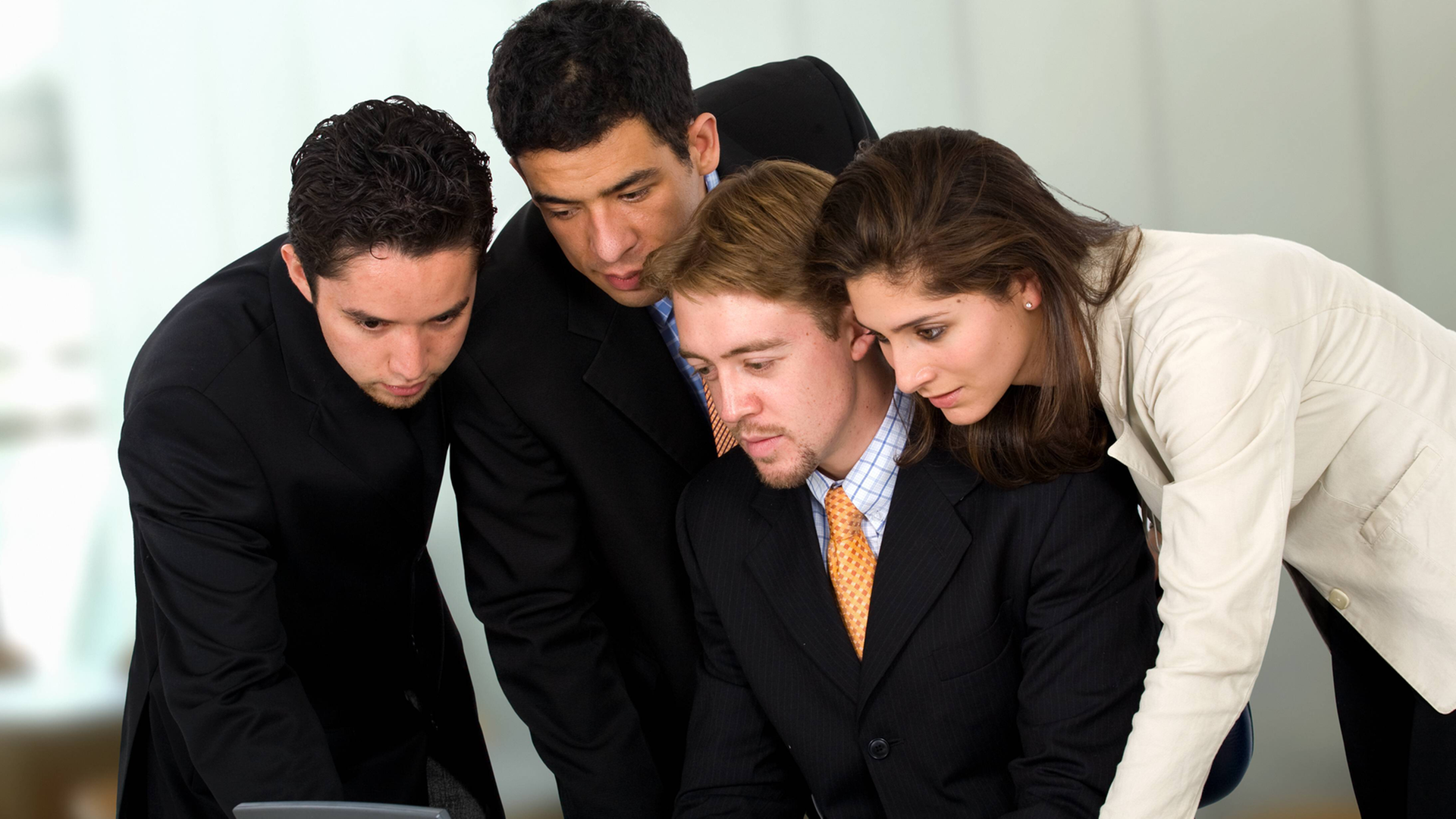 Ein Mann und eine Frau in Business-Look beugen sich gemeinsam über einen Laptop-Computer Ein Mann und eine Frau in Business-Look beugen sich gemeinsam über einen Laptop-Computer